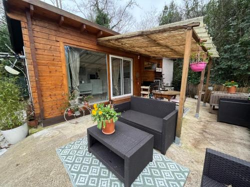 een patio in de achtertuin met een bank en een pergola bij La Cabane in Le Bar-sur-Loup