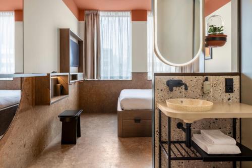 a hotel room with a sink and a bed at The Usual Rotterdam in Rotterdam