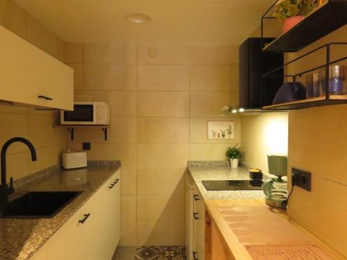 a small kitchen with a sink and a microwave at Casa Rural Artola in Astigarraga