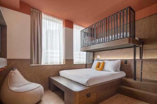 ロッテルダムにあるThe Usual Rotterdamの小さな客室で、二段ベッド1組、椅子が備わります。
