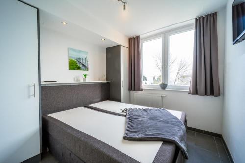 a bedroom with a bed with a blanket on it at Leuchtturm 10 in Großenbrode