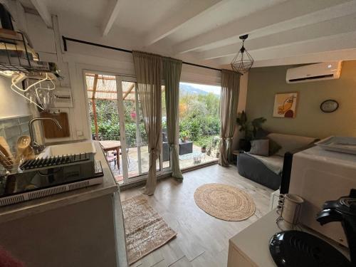 a kitchen and living room with a view of a patio at La Cabane in Le Bar-sur-Loup