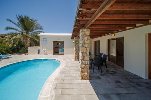 a villa with a swimming pool next to a house at Secret Oasis Villa Ladania in Coral Bay