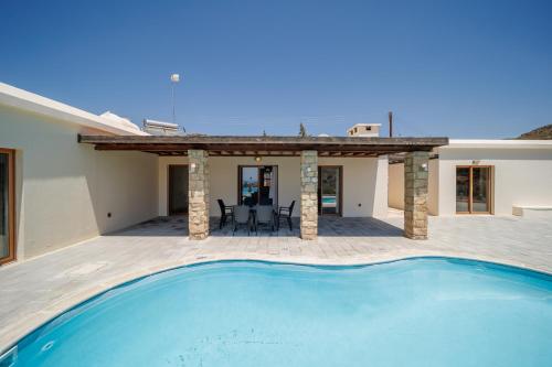 a villa with a swimming pool and a house at Secret Oasis Villa Ladania in Coral Bay