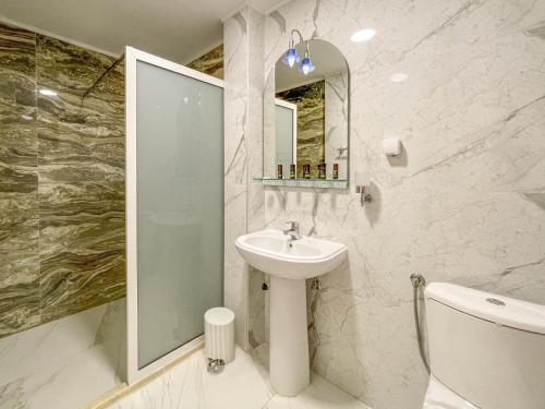 een witte badkamer met een wastafel en een spiegel bij Imperial Hotel in Ulcinj