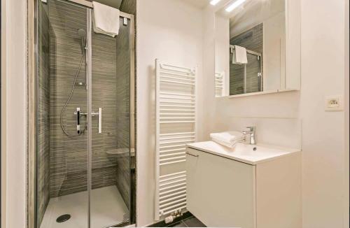 a white bathroom with a shower and a sink at Furnished 2 Bedroom Apartment in City Center in Brussels