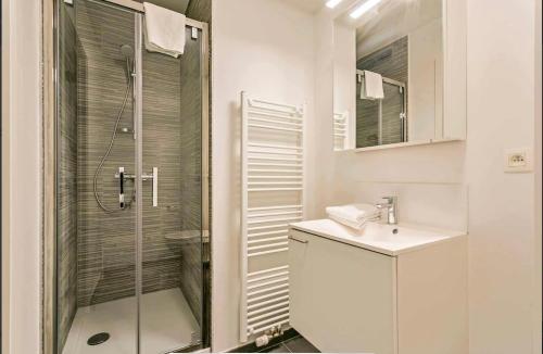 une salle de bain blanche avec une douche et un lavabo dans l'établissement Furnished 2 Bedroom Apartment in City Center, à Bruxelles