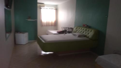 a small bedroom with a bed and a window at Hotel 1001 noites in Brasília