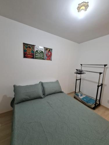 ein Schlafzimmer mit einem Bett mit zwei Bildern an der Wand in der Unterkunft Apto Decorado 2 quartos c/ Estacion-Jd Nova Europa-Campinas in Campinas