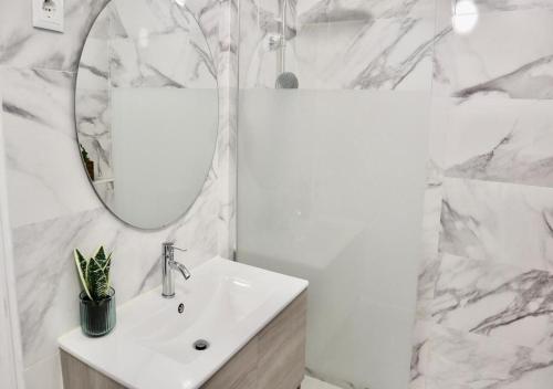 Baño blanco con lavabo y espejo en Matching Loures Guest House en Loures