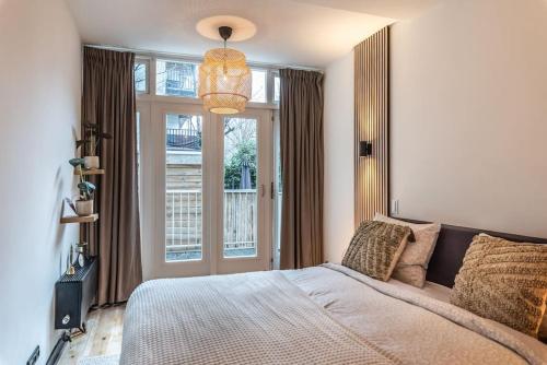 une chambre avec un grand lit et une fenêtre dans l'établissement CanalView Luxury Apartment, à Amsterdam