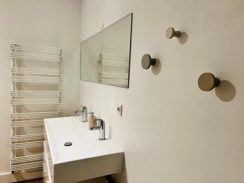 W białej łazience znajduje się umywalka i lustro. w obiekcie accademia00 w mieście Maastricht