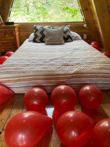 a room with a bed with red balloons on the floor at Cabañas Alpina, romántica y acogedora a 10 minutos del centro in Tepoztlán