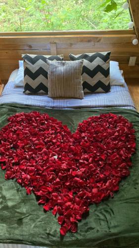 a heart made out of roses on a bed at Cabañas Alpina, romántica y acogedora a 10 minutos del centro in Tepoztlán