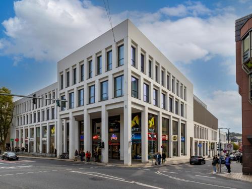 a white building on the corner of a street at B&B Hotel Marburg in Marburg an der Lahn