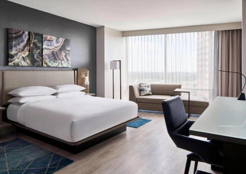 - une chambre avec un lit, un bureau et un canapé dans l'établissement Bethesda North Marriott Hotel & Conference Center, à Bethesda
