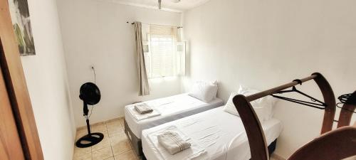 ein kleines Zimmer mit zwei Betten und einem Fenster in der Unterkunft Casa Sapucaia - Praia in Santa Cruz Cabrália