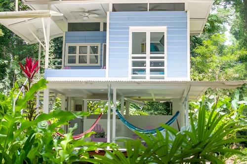 a blue house with a hammock in front of it at Jungle Dreamz in Manzanillo