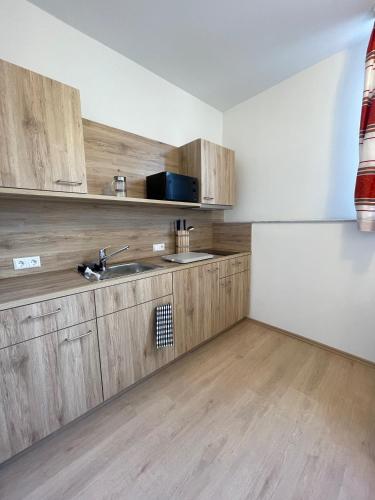a kitchen with wooden cabinets and a sink at Hotel am Römerplatz in Ulm