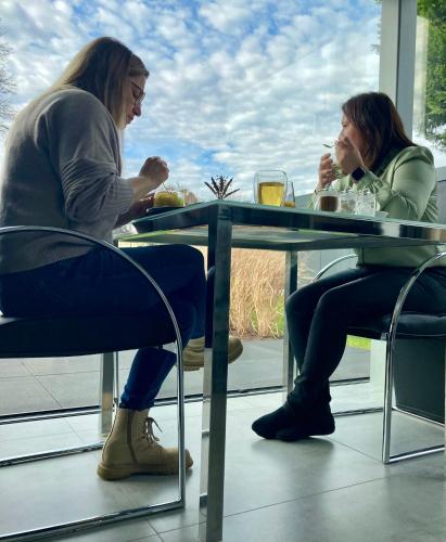 two women sitting at a table in a restaurant at B&B La Miniera in Genk