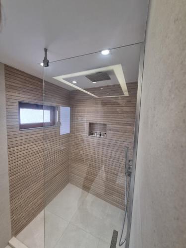 a bathroom with a shower with a glass door at HOTEL VILA TWIX in Berat