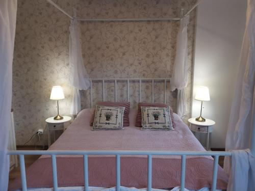 1 dormitorio con 1 cama con 2 almohadas y 2 lámparas en Apartament Dragoste și Lavandă Sinaia, en Sinaia