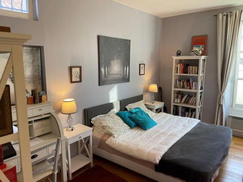 Un dormitorio con una cama con almohadas azules. en Appartement Versailles château, en Versalles