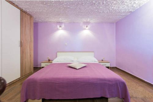 a purple bedroom with a bed with a purple blanket at Apartments Villa Bosotina in Kukljica