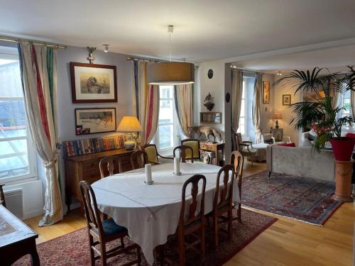 Appartement Versailles château في فرساي: غرفة طعام مع طاولة وغرفة معيشة
