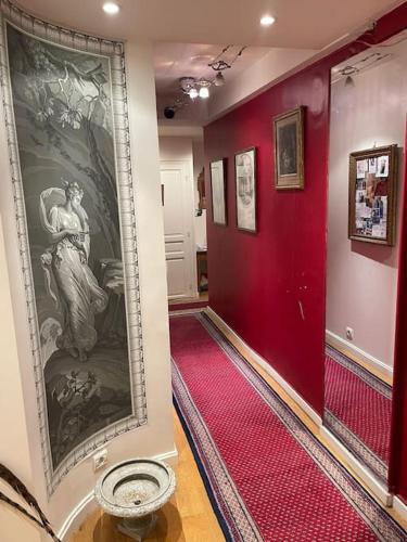 un couloir avec des murs rouges et une peinture murale dans l'établissement Appartement Versailles château, à Versailles