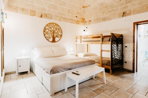 1 dormitorio con 1 cama, 1 litera y 1 mesa en Le Contrade via Roma, en Monopoli