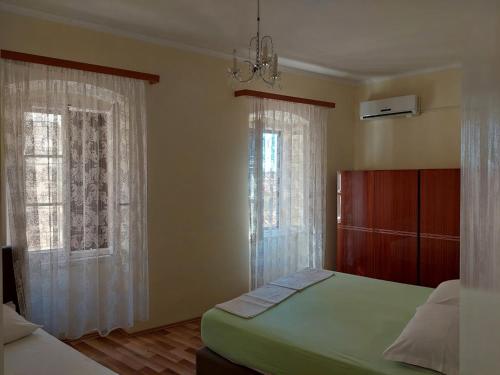 a bedroom with two beds and two windows at Apartman Dina in Komiža