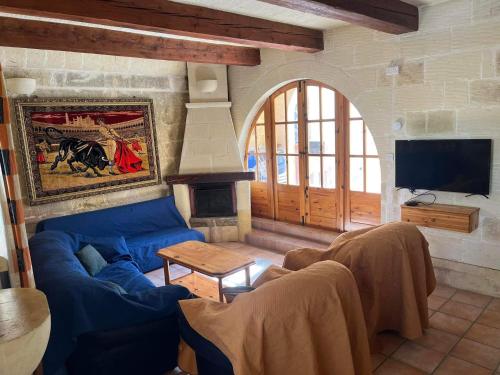 サーナにあるFarmhouse with Pool, Tas-Summiena Gozoのリビングルーム(青いソファ、暖炉付)