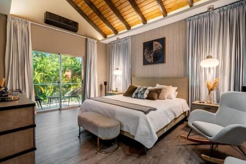 a bedroom with a bed and a chair and a window at Modern village between mountains Villa la Justina in Constanza