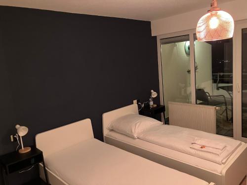 a bedroom with two beds and a black wall at Ferienwohnung Talblick in Beffendorf