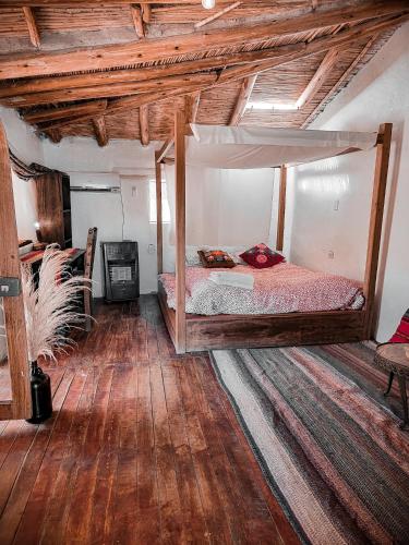 a bedroom with a bed in a room with wooden ceilings at Wolf Totem Lux Backpacker Villa in Pisac
