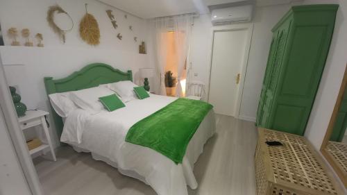 a bedroom with a green and white bed and a green door at El rinconet in Partida de La Cañada