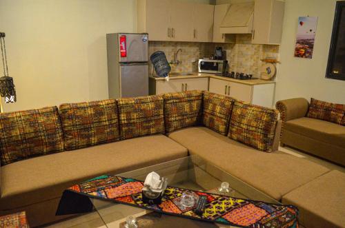 a living room with a couch and a kitchen at Landmark III High Rated Apartment in Islamabad