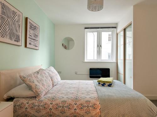 een slaapkamer met een bed en een raam bij Luxury 2 Bedroom City Centre Apartment - Secure Parking - Amazing location! in Canterbury