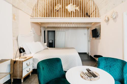 a bedroom with a bed and two tables and chairs at Le Contrade Chiasso Cafaro in Monopoli