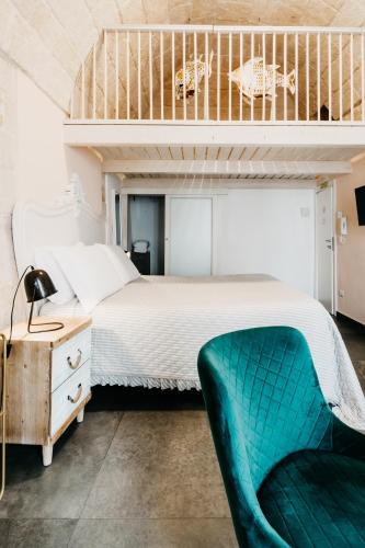a bedroom with a bunk bed and a green chair at Le Contrade Chiasso Cafaro in Monopoli