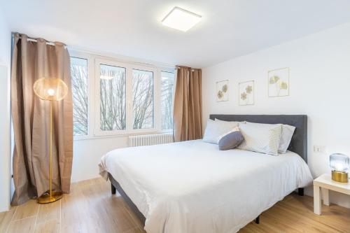 een slaapkamer met een groot wit bed en ramen bij Loft Salgari in Turijn