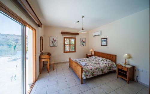 a bedroom with a bed and a large window at Secret Oasis Villa Ladania in Coral Bay