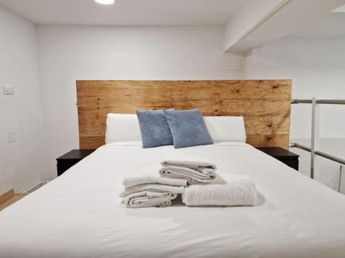 a bedroom with a white bed with towels on it at Loft Seco super equipado cerca de metro Pacífico in Madrid