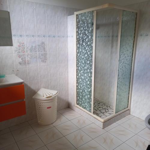 um chuveiro na casa de banho com uma lata de lixo em Villa bella em Sainte-Anne