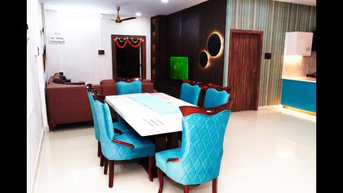 a dining room with a table and blue chairs at Mandolin Homestay in Dibrugarh - 2BHK Apartment in Dibrugarh