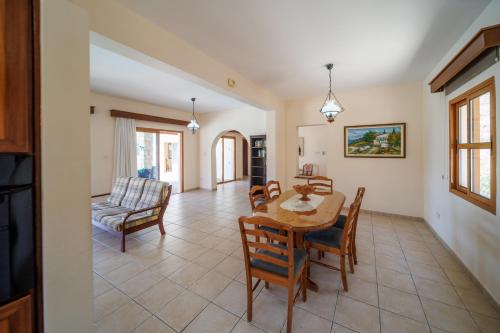 a dining room and living room with a table and chairs at Secret Oasis Villa Ladania in Coral Bay