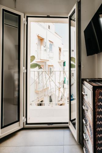 a room with a window with a view of a building at Le Contrade Chiasso Cafaro in Monopoli