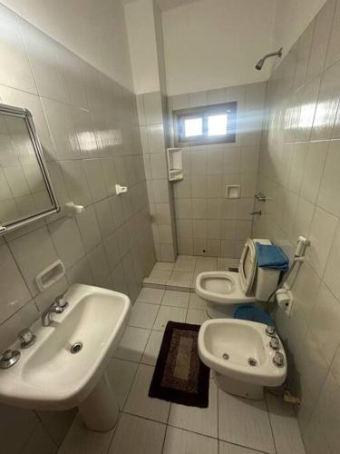 a white bathroom with a sink and a toilet at Departamento Circuito Comercial in Encarnación