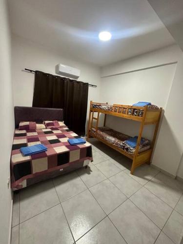 a bedroom with a bed and a bunk room with a bunk bed at Departamento Circuito Comercial in Encarnación